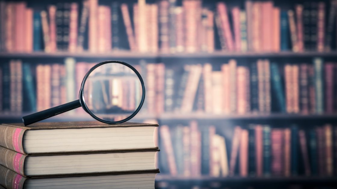 Magnifying Glass on top of book stack