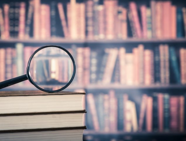 Magnifying Glass on top of book stack