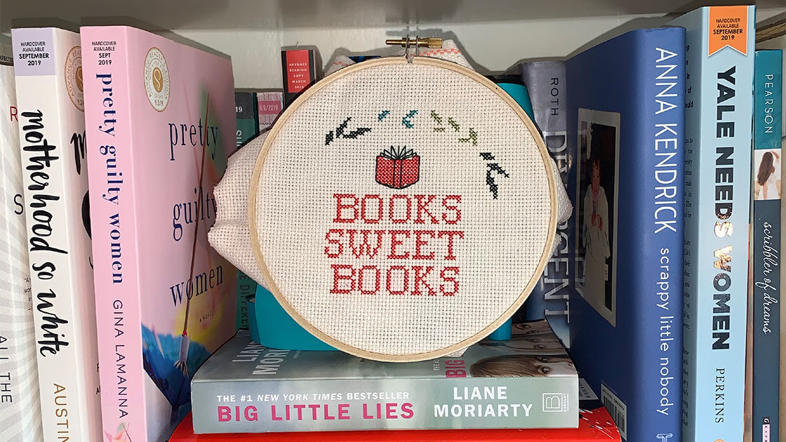 Bookish cross stitch on book shelves